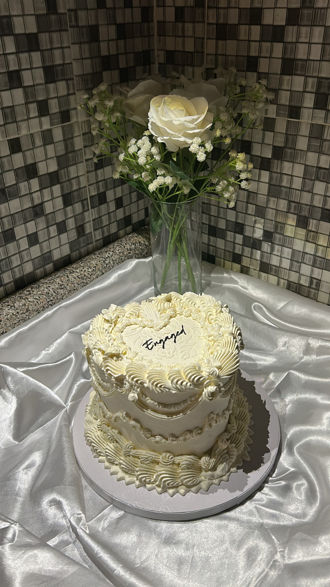 White engagement cake with intricate piping and flowers